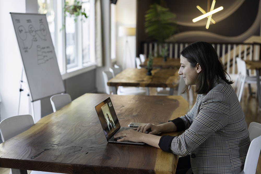 穿着灰色和白色条纹长袖衬衫的女人使用银色 macbook