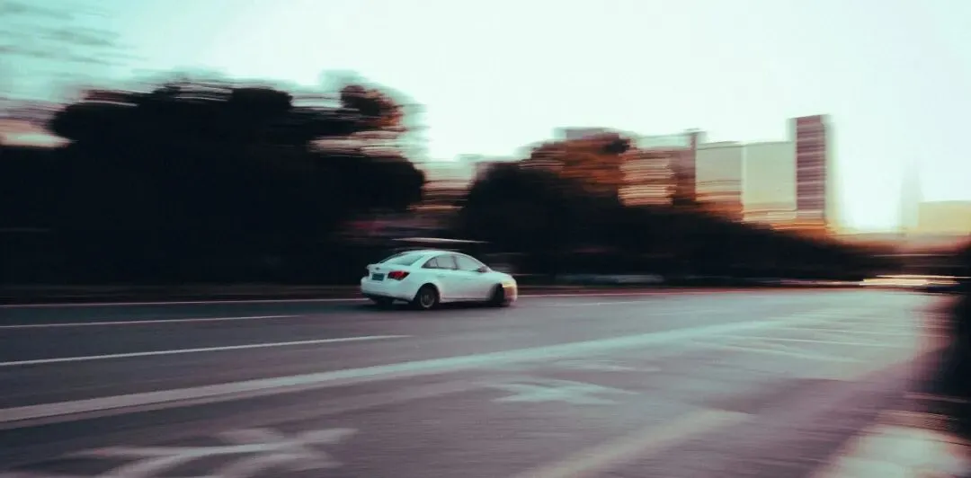 白天行駛的白色轎車