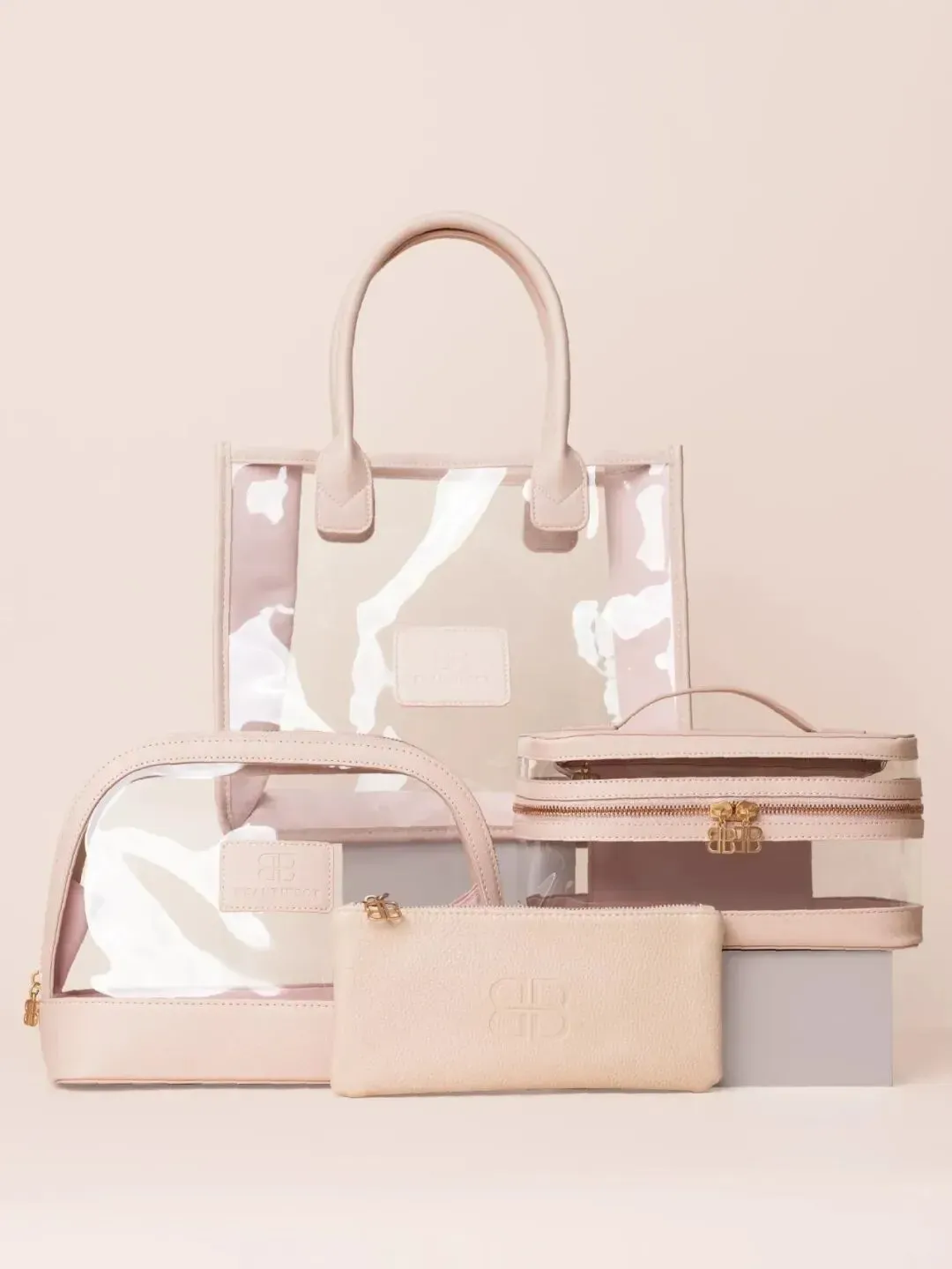 Nude Bag Collection stacked on a blush backdrop: tote, vanity bag, toiletry bag and pouch