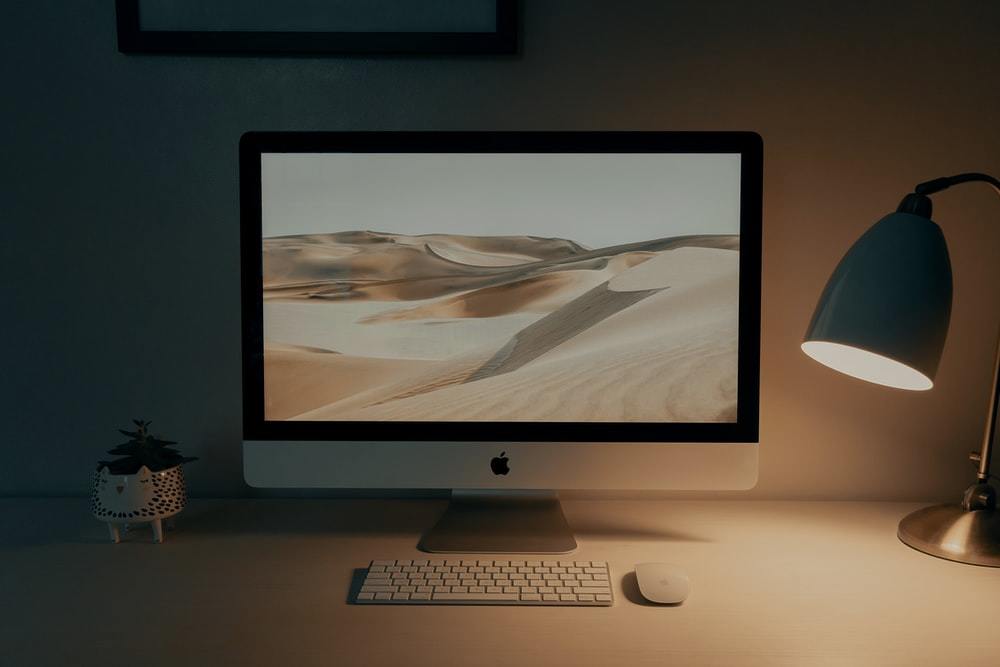 棕色木桌上的银色 imac