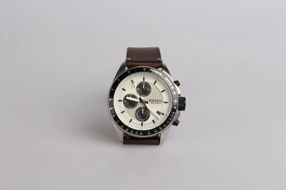 round silver-colored Fossil chronograph watch at 9:22 with brown leather band