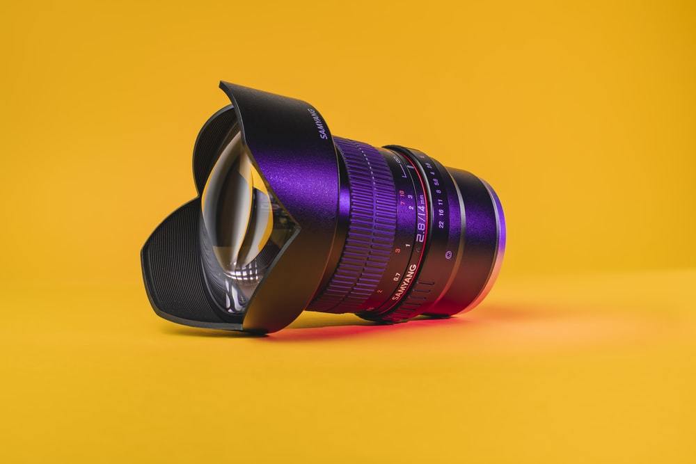 black camera lens on yellow surface