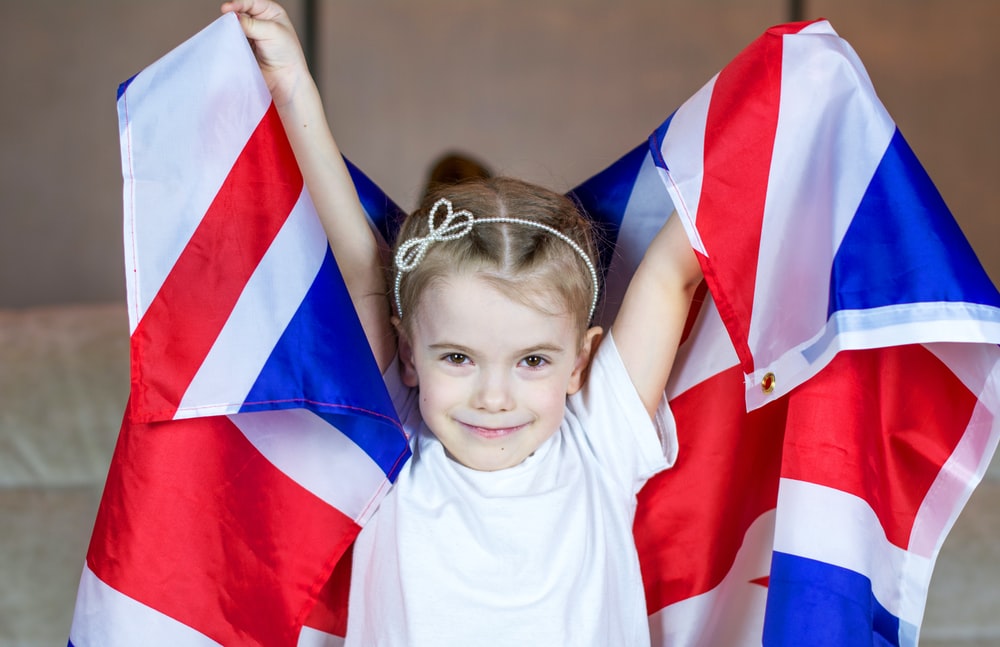 girl in white crew neck t-shirt holding red and blue flag