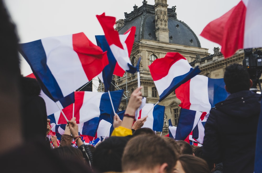 人们在街上举着法国国旗