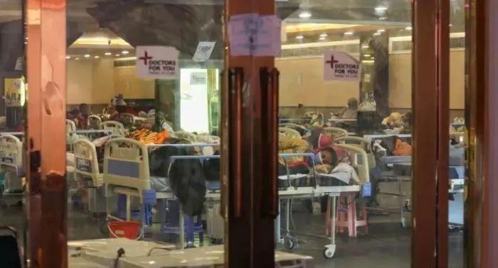 4月27日,印度通报新增逾32万新冠确诊病例,连续第6天超过30万例,累计确诊升至近1800万,死亡人数逼近20万。连续激增的确诊病例,导致印度多地医疗系统瘫痪,许多患者只能在临时搭建的场所接受治疗。图为印度新德里一个由宴会厅临时改建的隔离病房中住满了新冠患者。